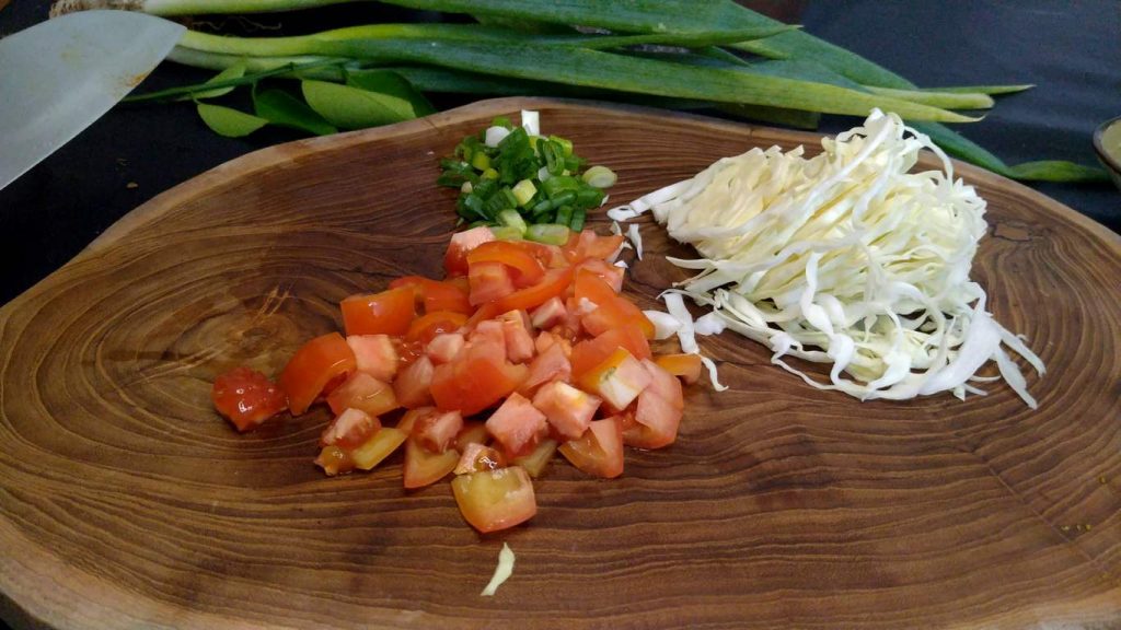 cut tomatoes, cabbage and onion leaves for the soup