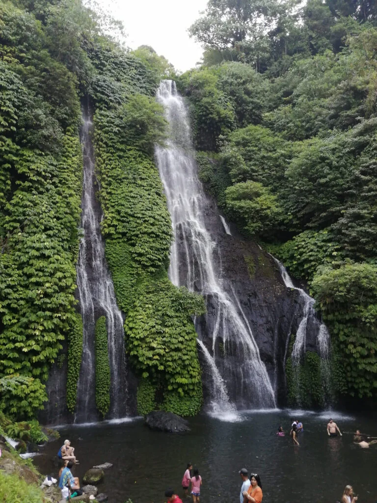 Banyumala Waterfall with people swimming